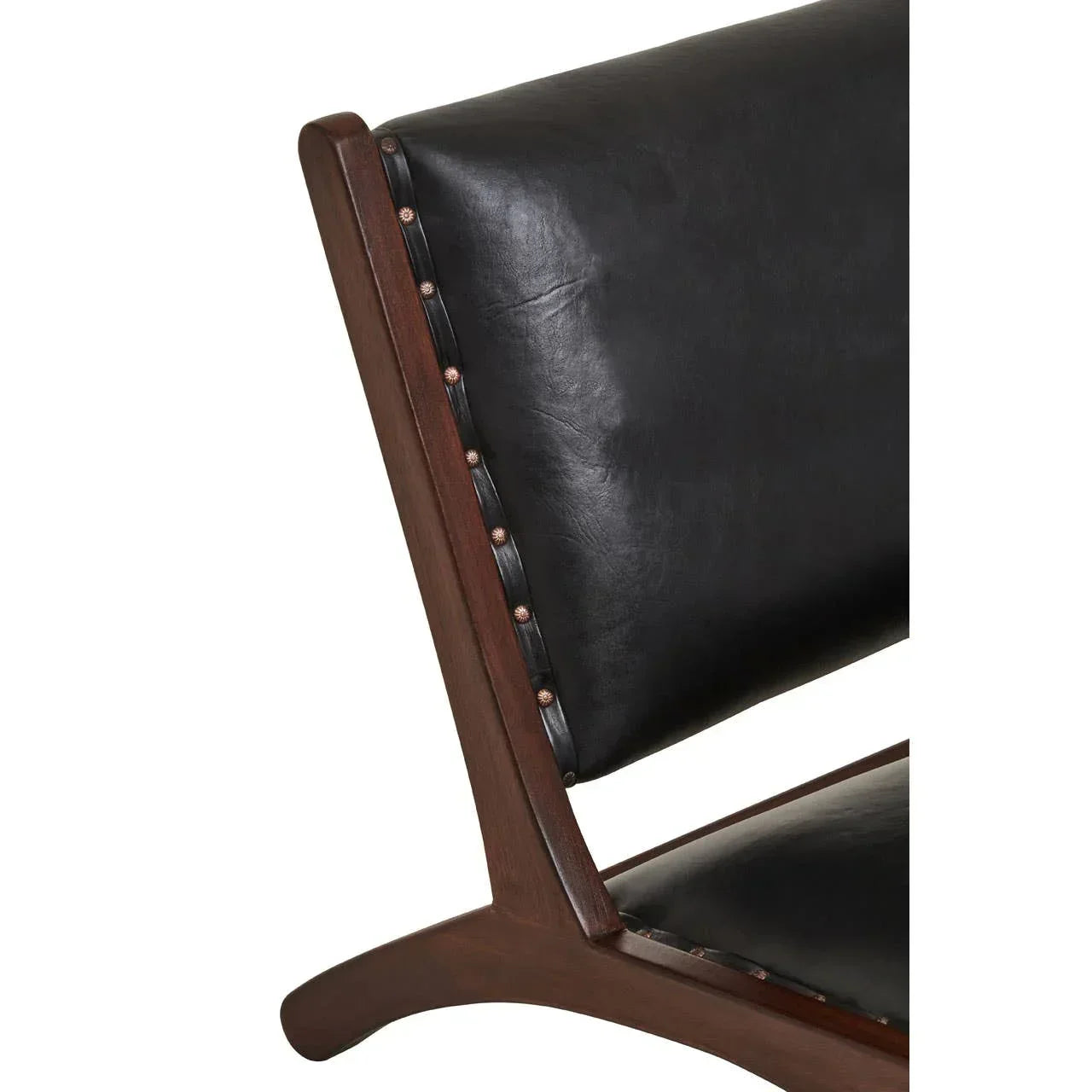 Close-up of black leather chair with dark wood frame and nailhead trim