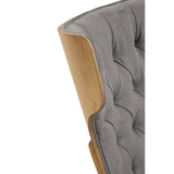 Dark grey velvet chair featuring a winged back design and tufted upholstery. The chair's wooden frame has a natural finish, highlighting the elegant curves and contours.