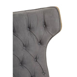 Dark grey velvet chair featuring a winged back design with tufted upholstery and decorative buttons.
