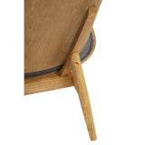 Dark grey velvet chair featuring a winged back design, supported by sturdy wooden legs.
