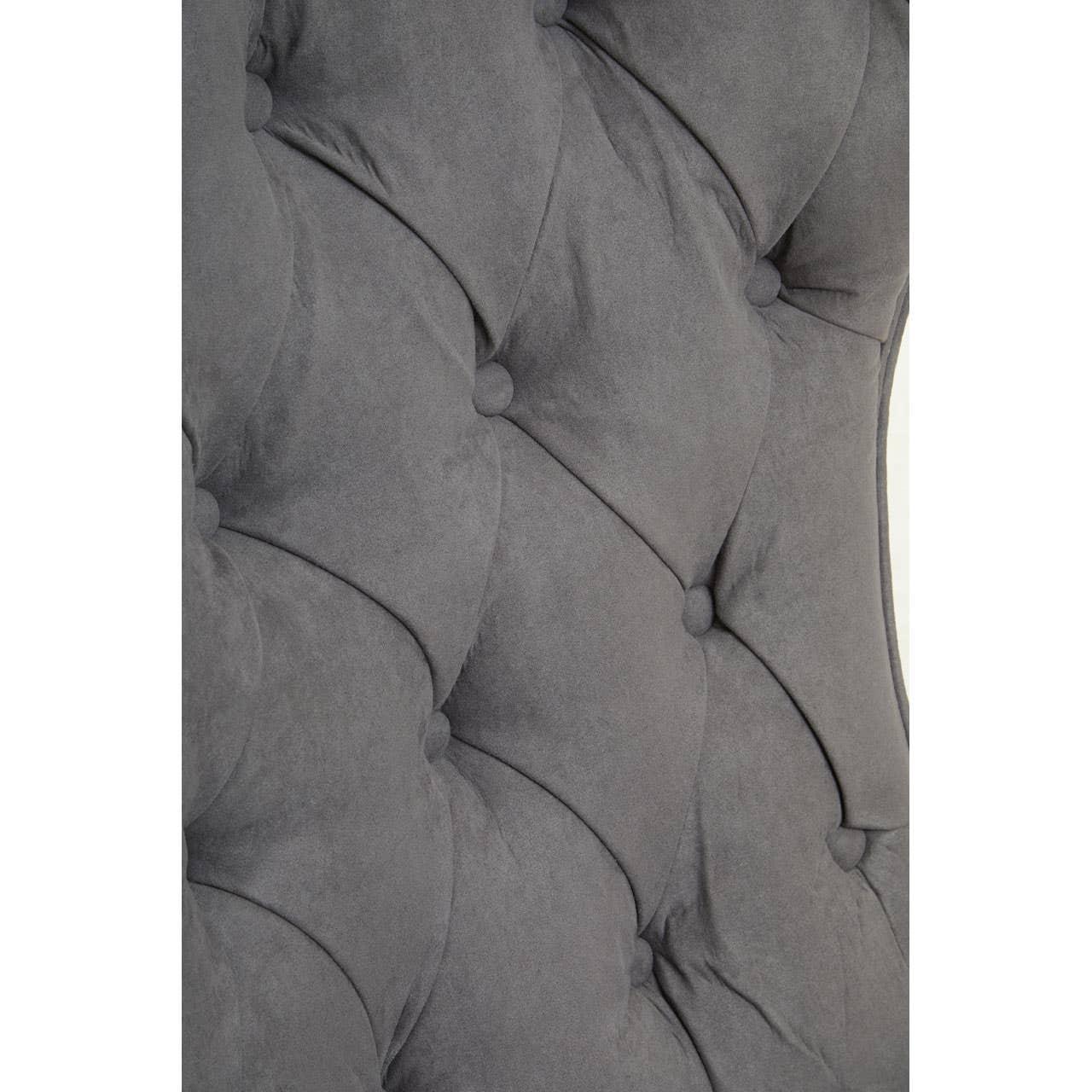 Grey upholstered headboard with deep button tufting and soft fabric texture detail