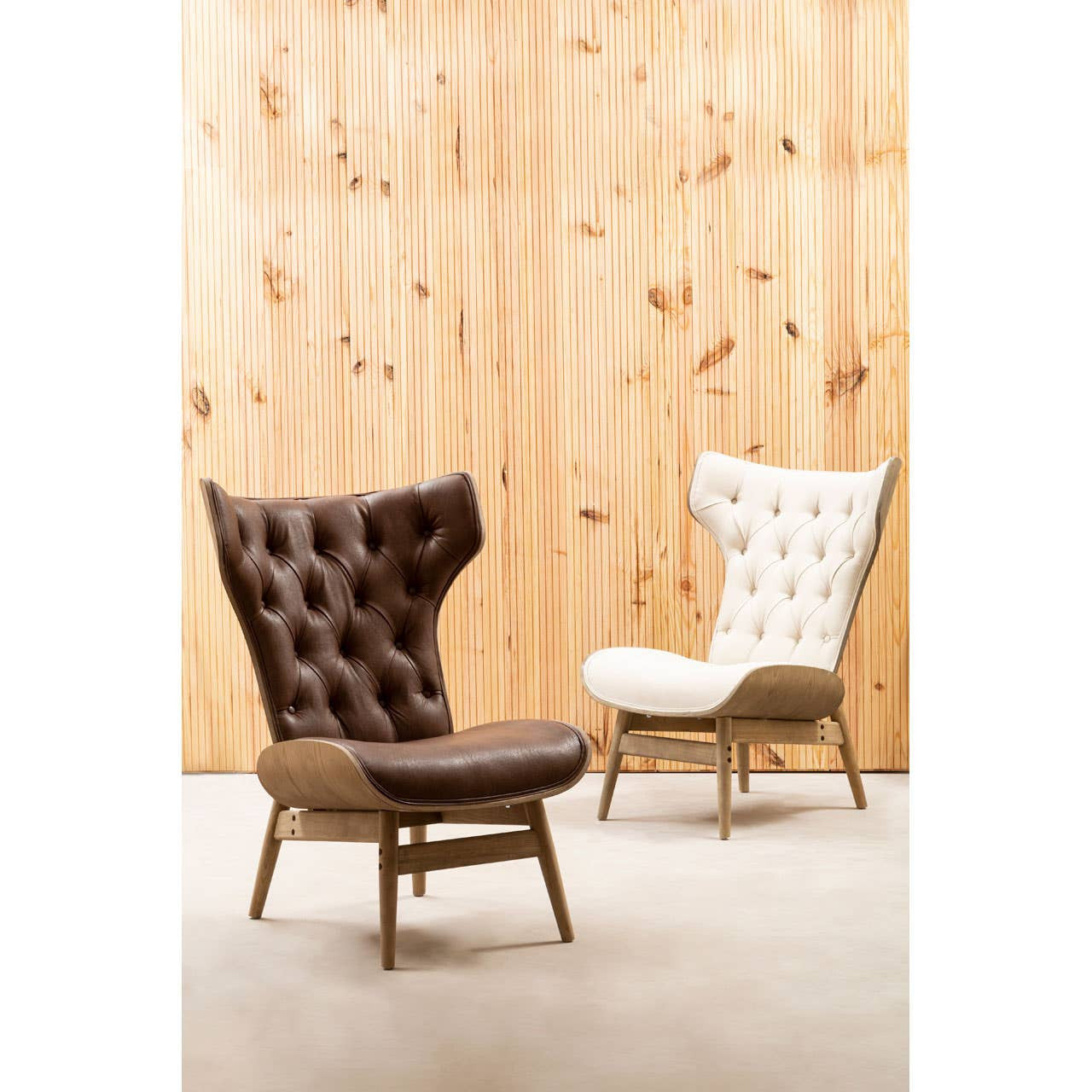 Brown leather effect chair featuring a winged back and tufted upholstery, set against a textured wooden wall.