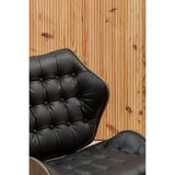 Black leather effect chair featuring a tufted design with button detailing, set against a warm wooden backdrop.