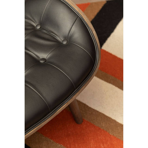 Black leather effect chair featuring a tufted seat with button detail, complemented by a curved wooden frame.