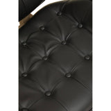 Close-up view of a black leather effect chair featuring a tufted design with button detailing.
