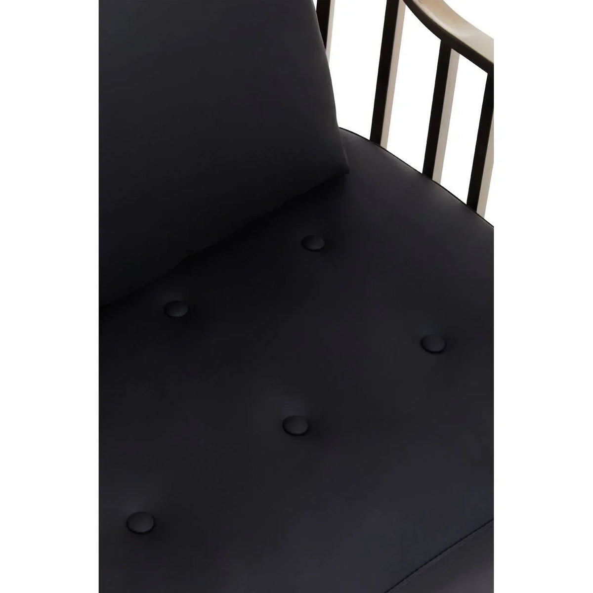 Close up of black upholstered armchair seat with tufted buttons and metal frame