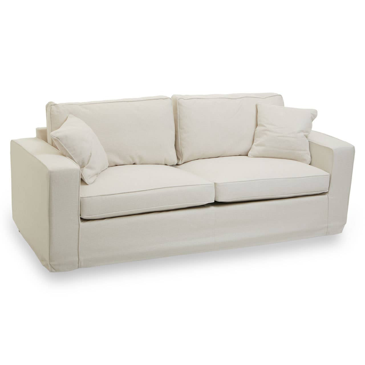 Cream fabric sofa with three seats, featuring two large back cushions and two smaller decorative pillows, all set on a low-profile base. The sofa has clean lines and a modern design, suitable for various interior styles