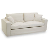Cream fabric sofa with three seats, featuring two large back cushions and two smaller decorative pillows, all set on a low-profile base. The sofa has clean lines and a modern design, suitable for various interior styles