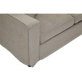 A close-up view of the corner of a grey sofa featuring a clean, modern design with straight lines and a soft fabric texture. The sofa has a low profile and is supported by small, discreet legs. The cushion appears plush and comfortable, enhancing the overall inviting look of the furniture piece