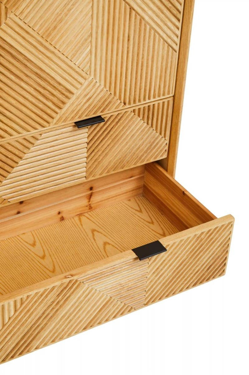 Natural wood cabinet featuring a geometric pattern on the front, with an open drawer showcasing a smooth interior and black metal handles. The cabinet has a light, natural finish that highlights the wood grain