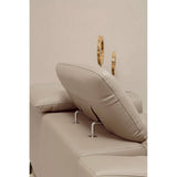 A close-up view of a stone leather sofa featuring adjustable headrests, showcasing the soft, plush texture of the upholstery and the sleek metal supports for the headrests. The background is a neutral color, enhancing the sofa's elegant design