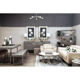 A stylish living room featuring a Padua 3 Seat Stone Leather Sofa with adjustable headrests, complemented by a round coffee table and a modern dining table with benches. The walls are painted in soft tones, and two framed artworks hang above the sofa, adding a touch of elegance. A sleek shelving unit is visible in the background, showcasing decorative items