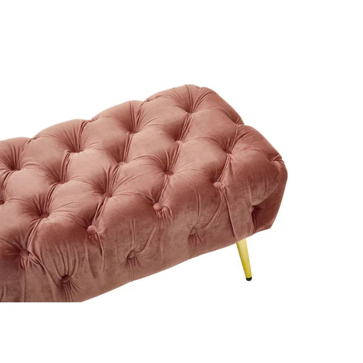 Blush pink velvet ottoman with button-tufted upholstery and gold metal legs, angled view