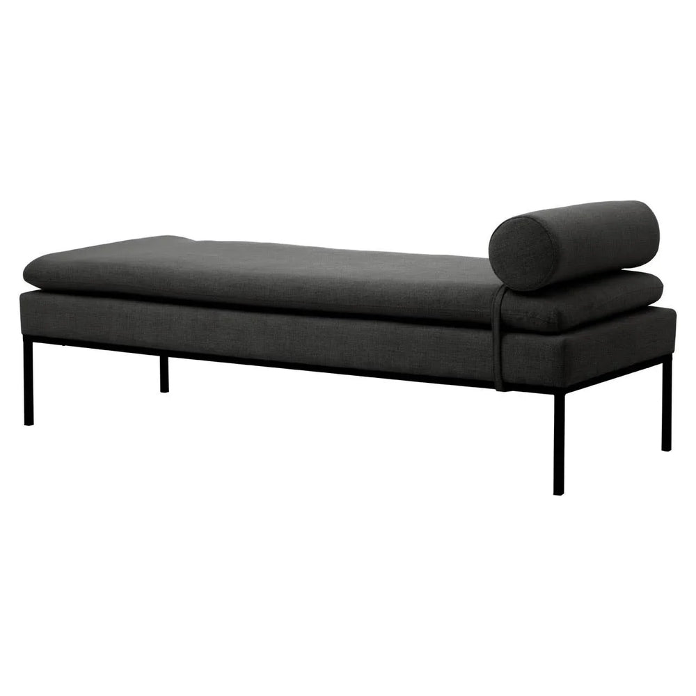 Dark grey fabric daybed with metal frame and cylindrical bolster pillow, side angle view