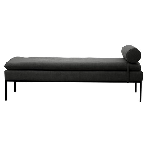 Dark grey upholstered daybed with cylindrical bolster and slim metal legs, side view