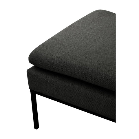 Closeup of dark grey fabric sofa corner with slim black metal leg