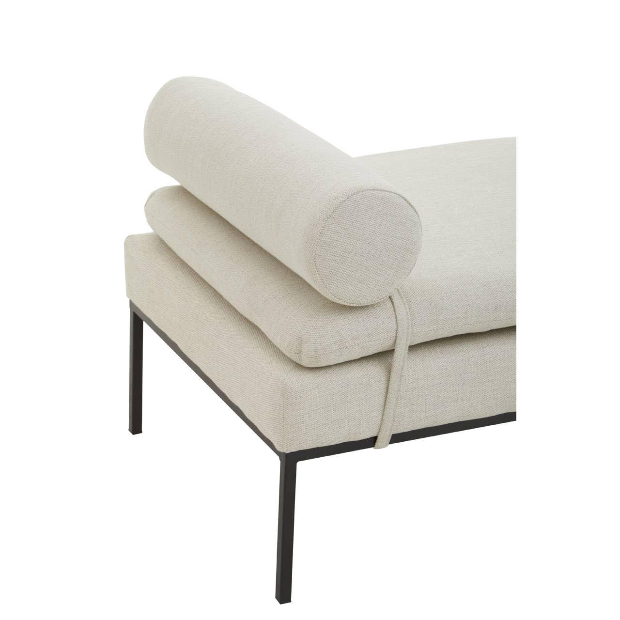 Beige upholstered bench with bolster cushion and black metal legs, close-up view