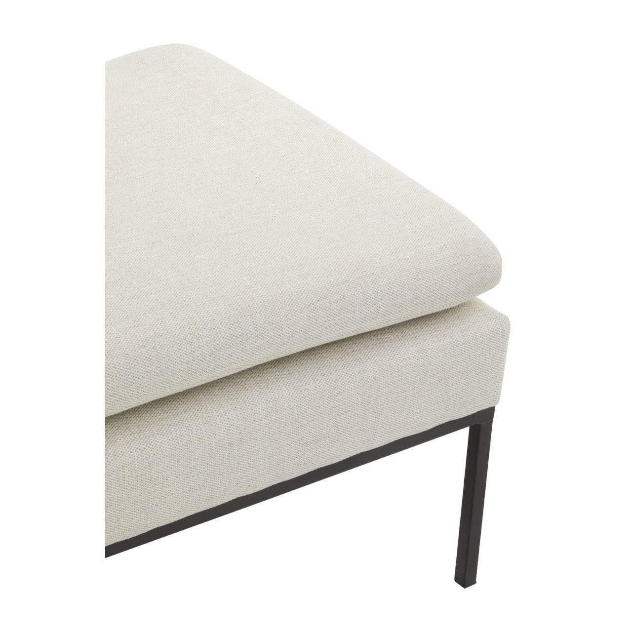 Close-up of cream fabric sofa corner with metal leg and cushioned seat