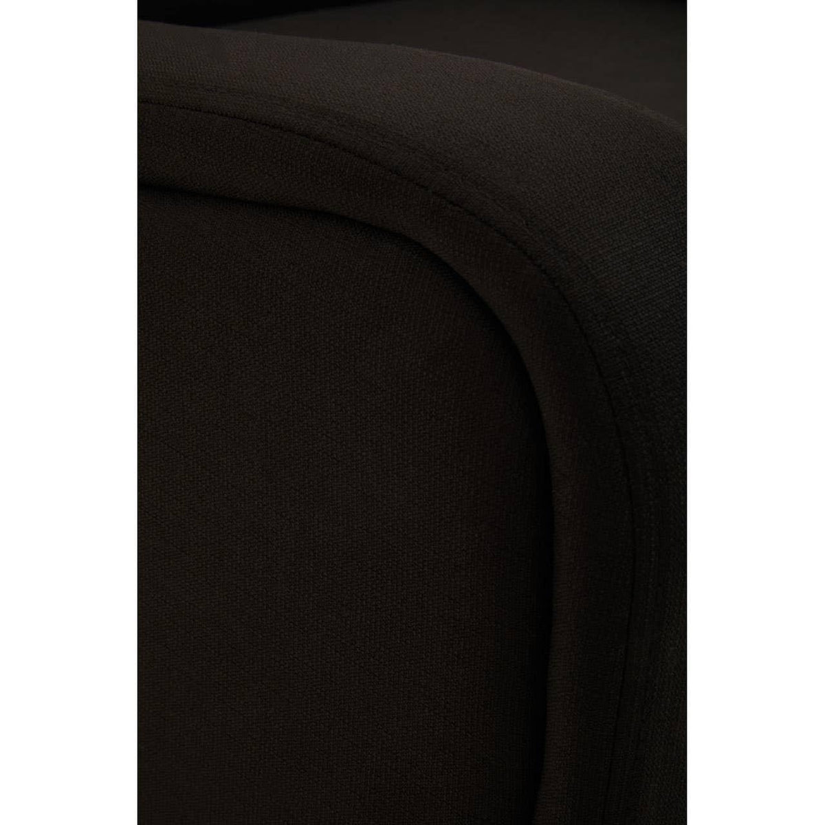 Close-up of dark fabric sofa armrest showing curved upholstery details