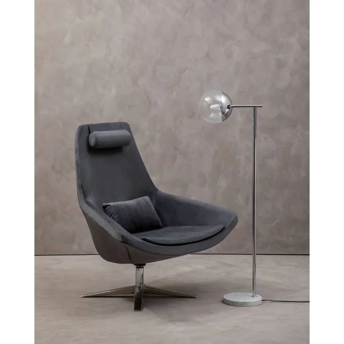 Grey swivel accent chair with padded headrest and cushion beside chrome floor lamp