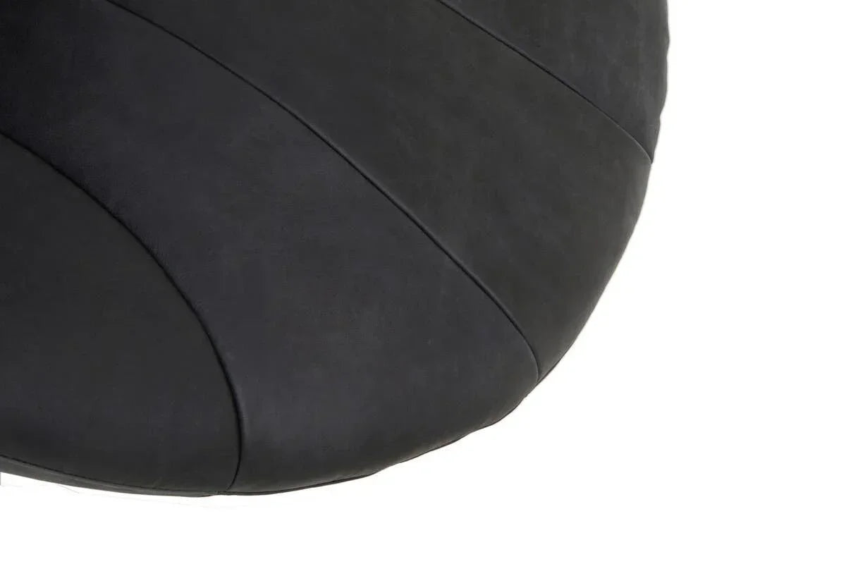Closeup of black upholstered chair seat with curved stitched detail