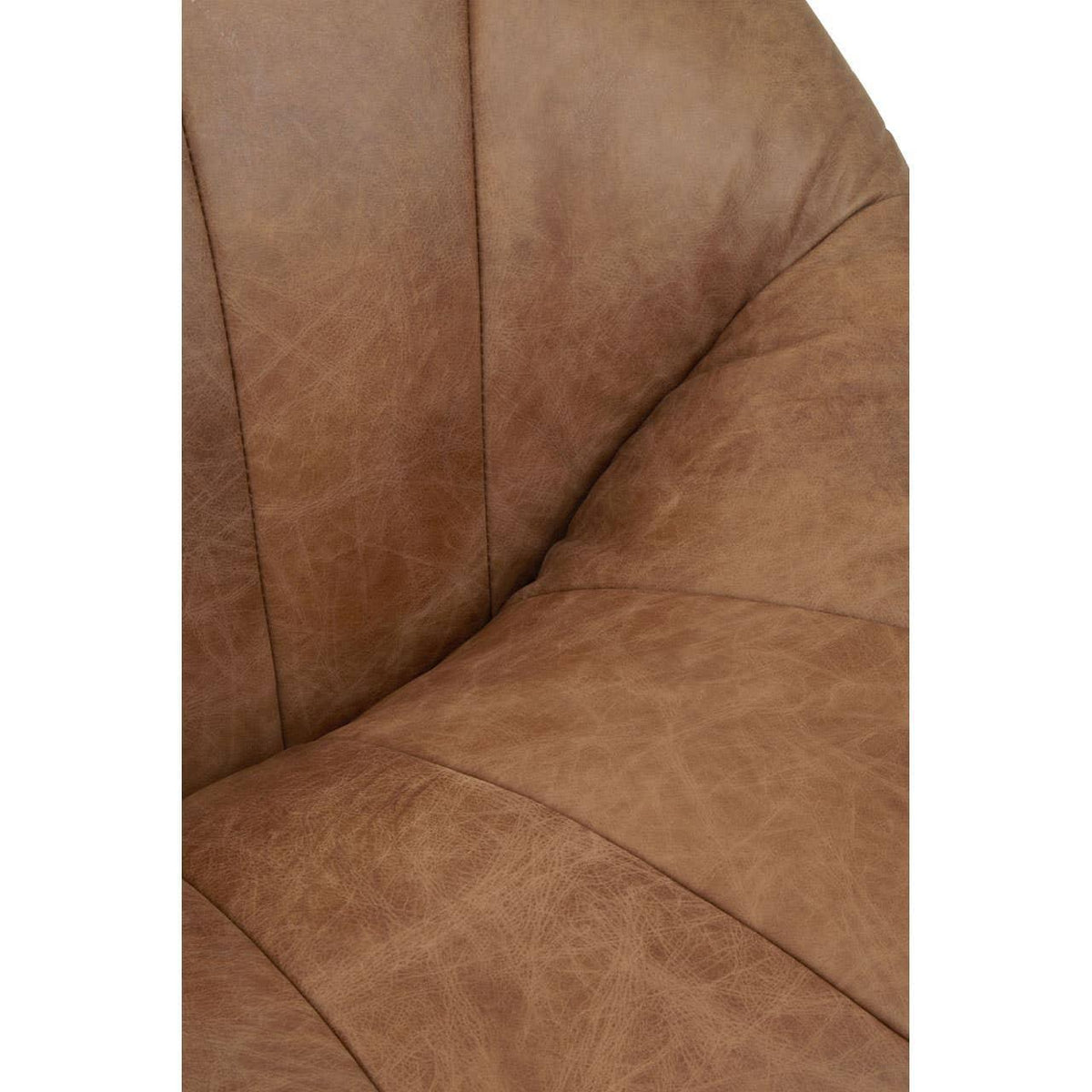Closeup of brown leather sofa seat cushion with stitched detail and textured finish