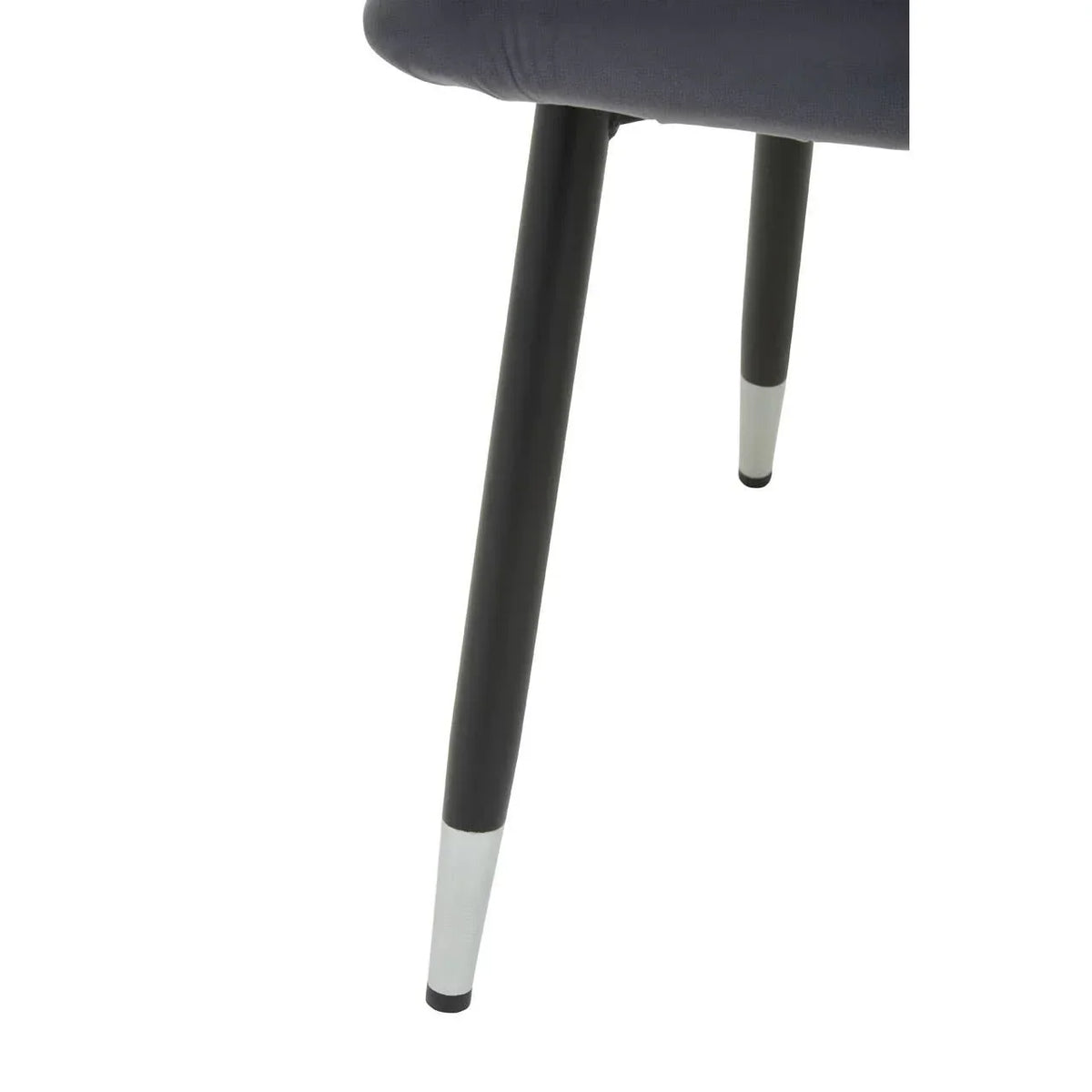 Black metal dining chair legs with silver capped tips, close-up view
