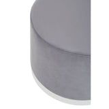 Round stool featuring a soft grey upholstery with a sleek silver base, showcasing a modern and minimalist design. The top surface is smooth and rounded, emphasizing its contemporary aesthetic
