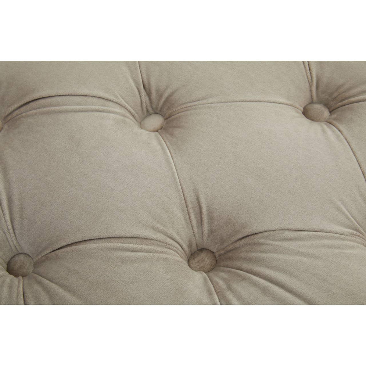 Beige fabric sofa cushion with deep button tufting detail, close-up view