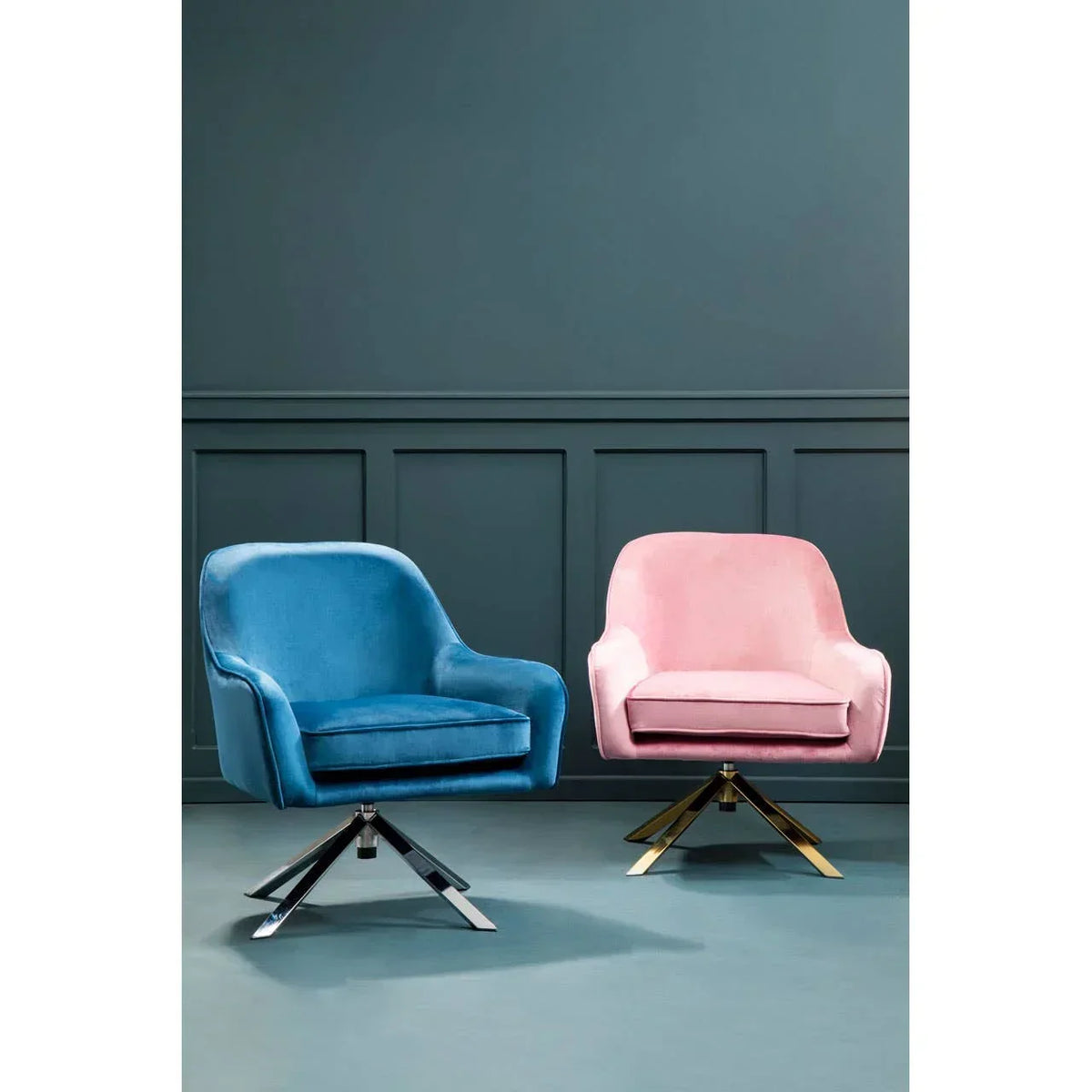 Blue and pink velvet swivel armchairs with metal legs against dark wall paneling