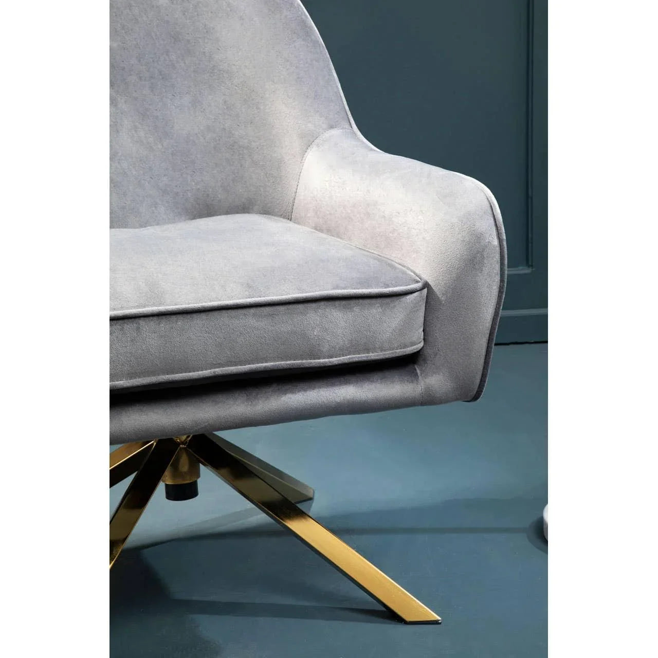 Grey velvet accent chair with gold metal swivel base, close view of seat and armrest
