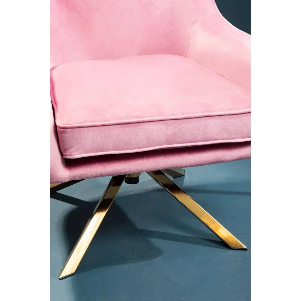 Pink velvet armchair with gold metal legs and plush seat cushion, side angle view