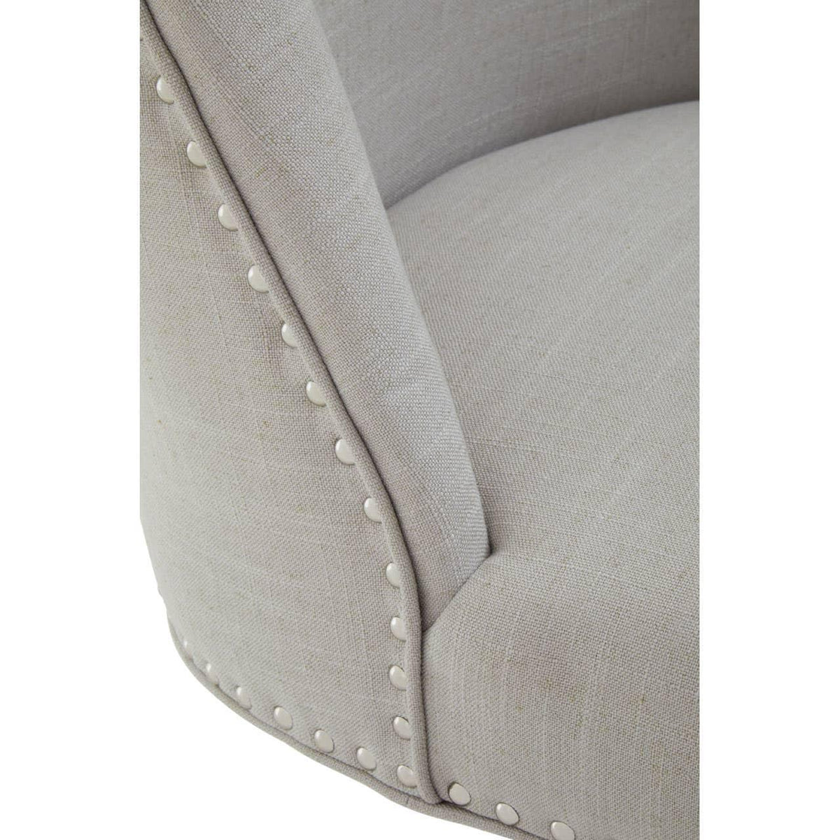 Close-up of beige fabric armchair with silver stud trim and soft seat cushion