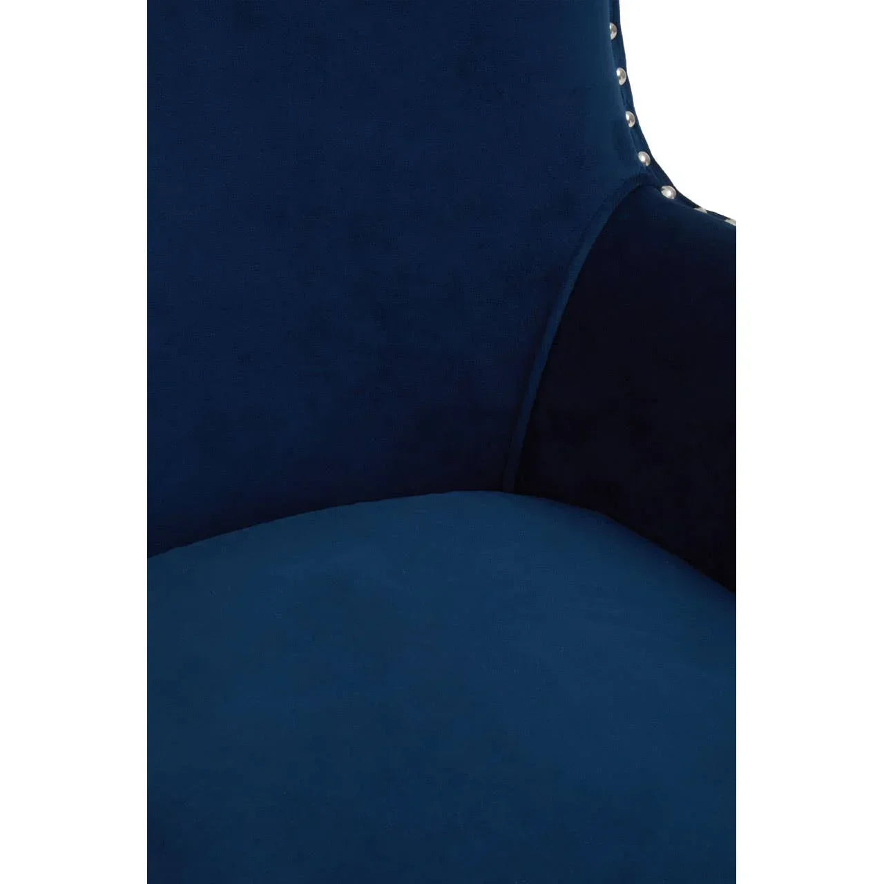 Close up of blue velvet armchair with silver stud detailing along the edge