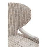 Close-up view of the Manado Wicker Chair showcasing its curved backrest and woven pattern in neutral tones, with a smooth, light-colored armrest visible on the side
