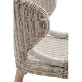 Wicker chair featuring a curved backrest and a textured seat, with light-colored woven material and wooden legs. The design showcases a natural, organic aesthetic suitable for home decor