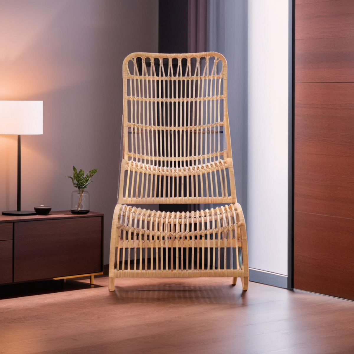 A stylish rattan chair with a high backrest and a matching footstool, both featuring a natural finish. The chair has a unique woven design and is positioned next to a modern lamp and a wooden side table in a contemporary room setting. A small potted plant is visible on the table, and the background includes a wooden wall