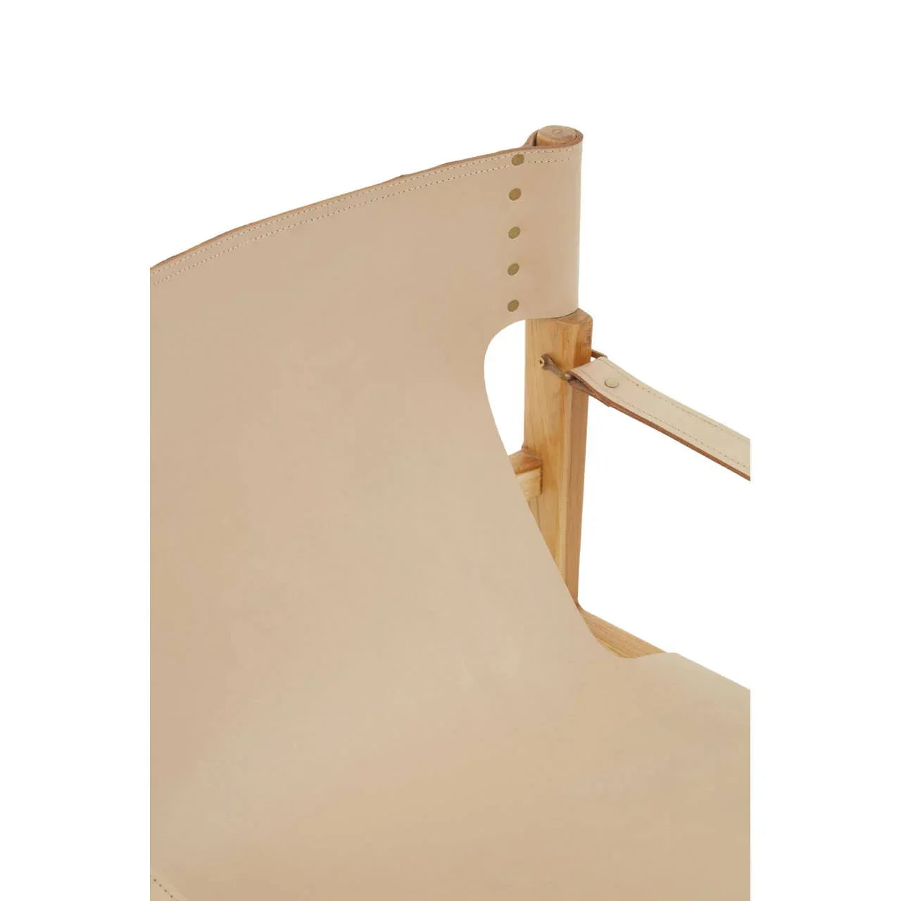Close-up of beige leather accent chair with wooden frame and brass rivet detail
