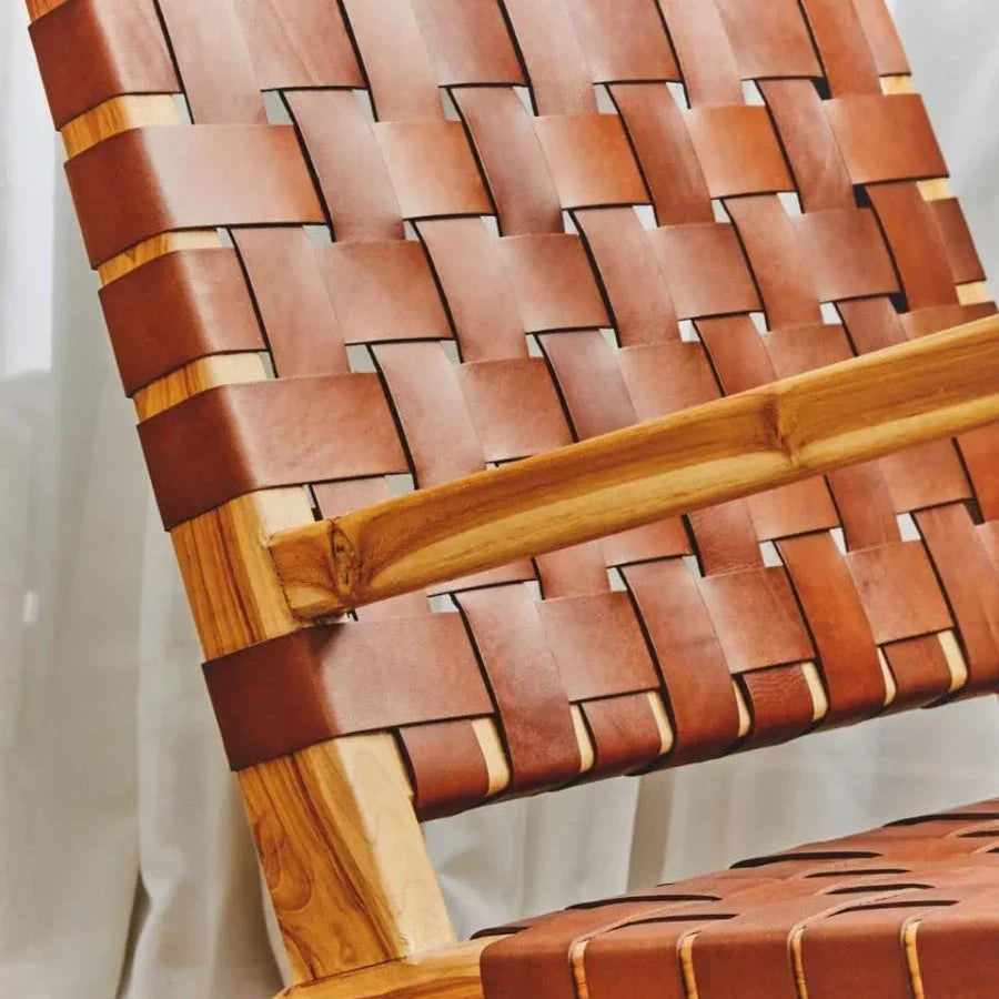 Brown leather woven lounge chair with wooden frame and natural finish, close-up view