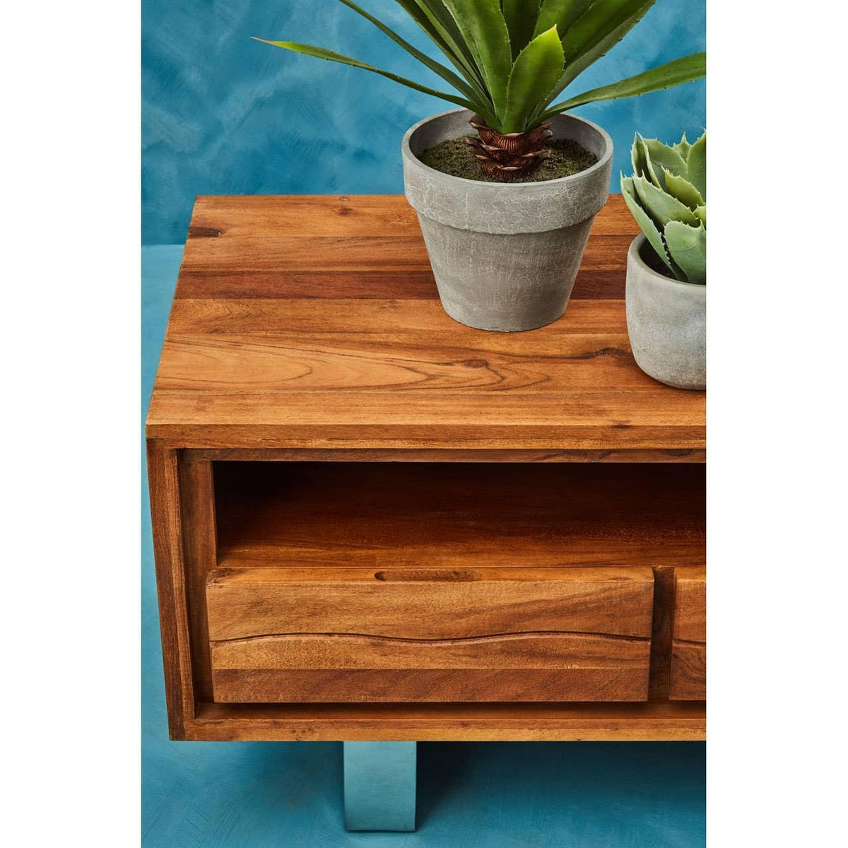 Wooden bedside table with drawer and open shelf, two potted plants on top