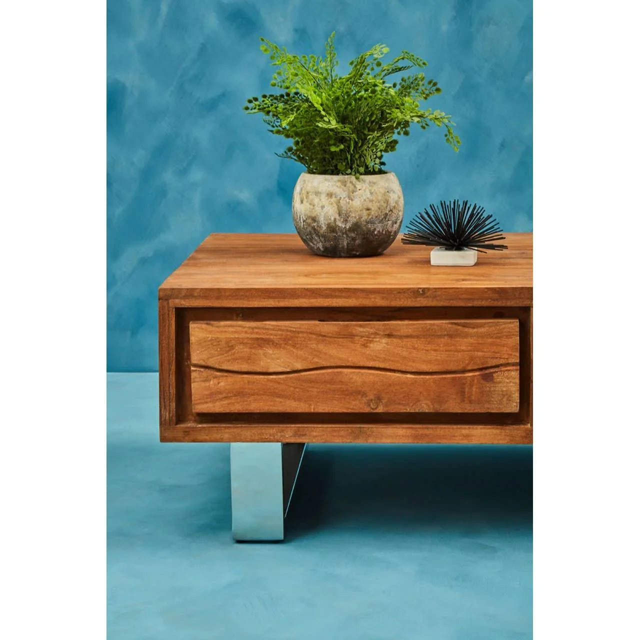 Solid wood coffee table with front drawer, metal legs, plant and decor on top