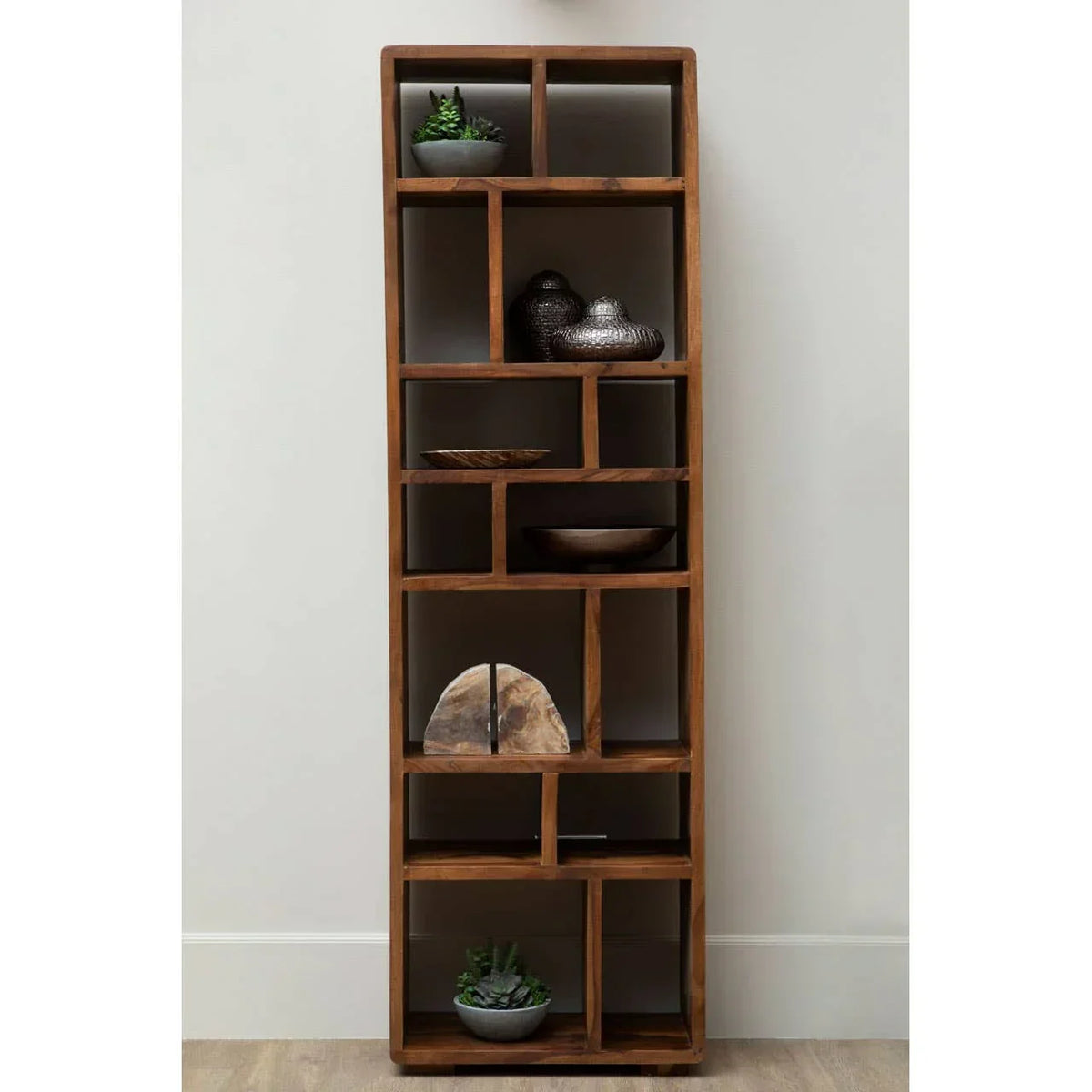 Tall wooden display unit with open shelves, decorative bowls, ornaments, and potted succulents