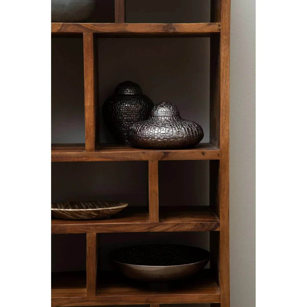 Dark metal decorative vases and bowls on wooden shelving unit