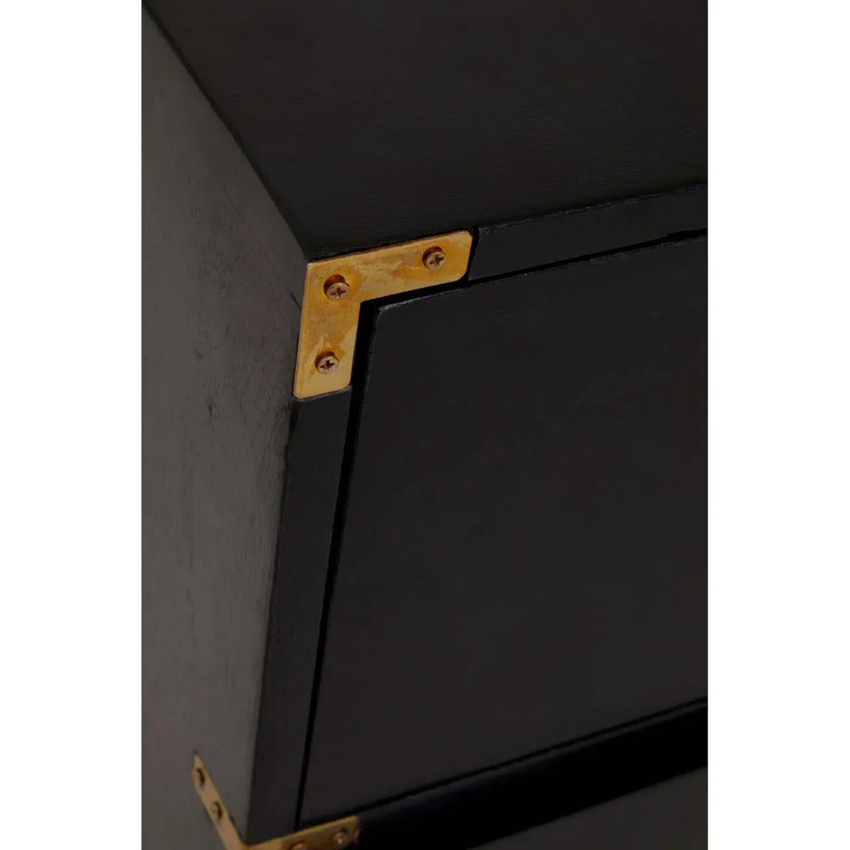Black furniture piece with gold metal corner detail and smooth matte finish