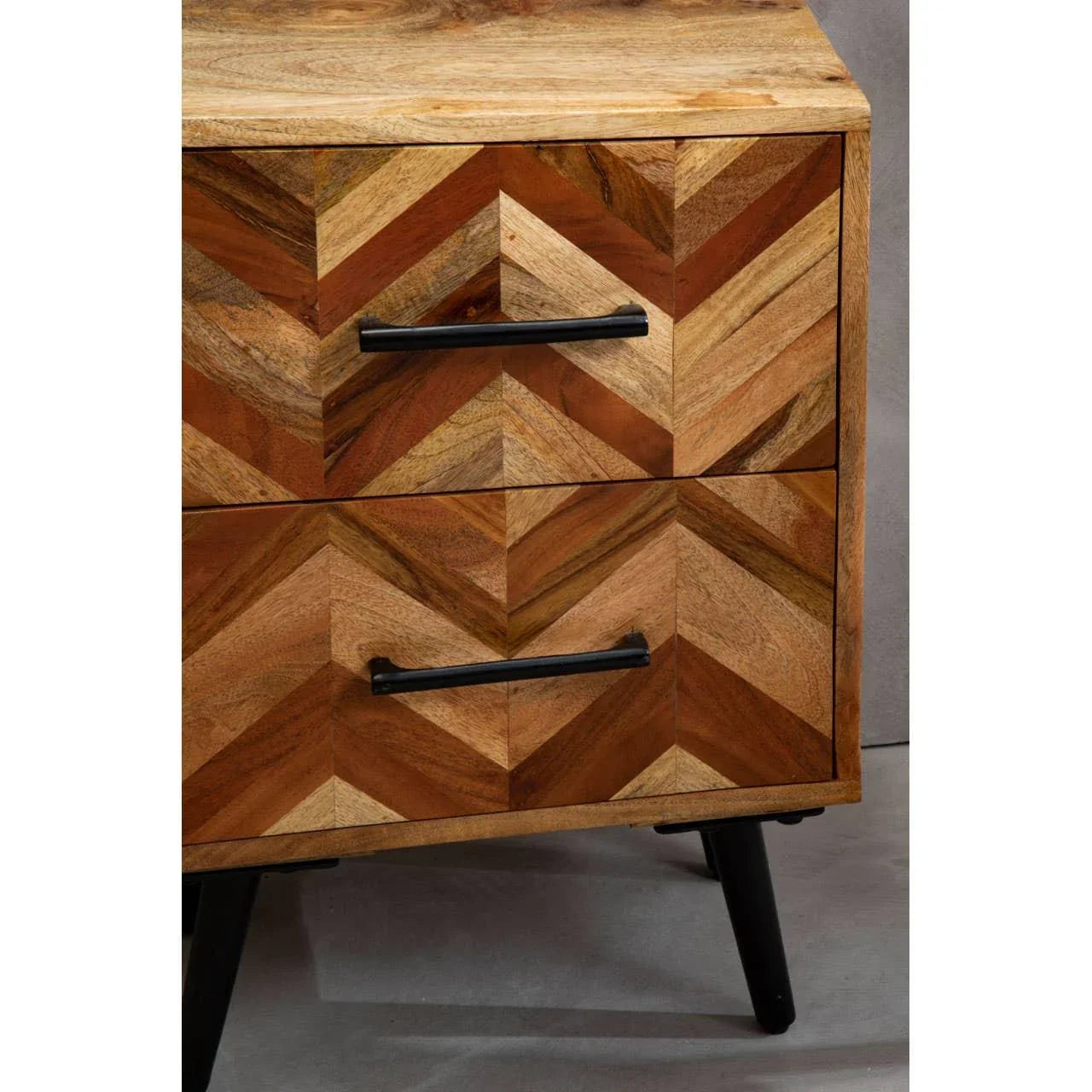 Chevron patterned wooden bedside table with black metal handles and angled legs