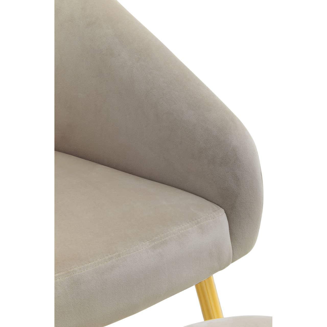 Close-up of beige fabric accent chair with padded seat and gold metal leg