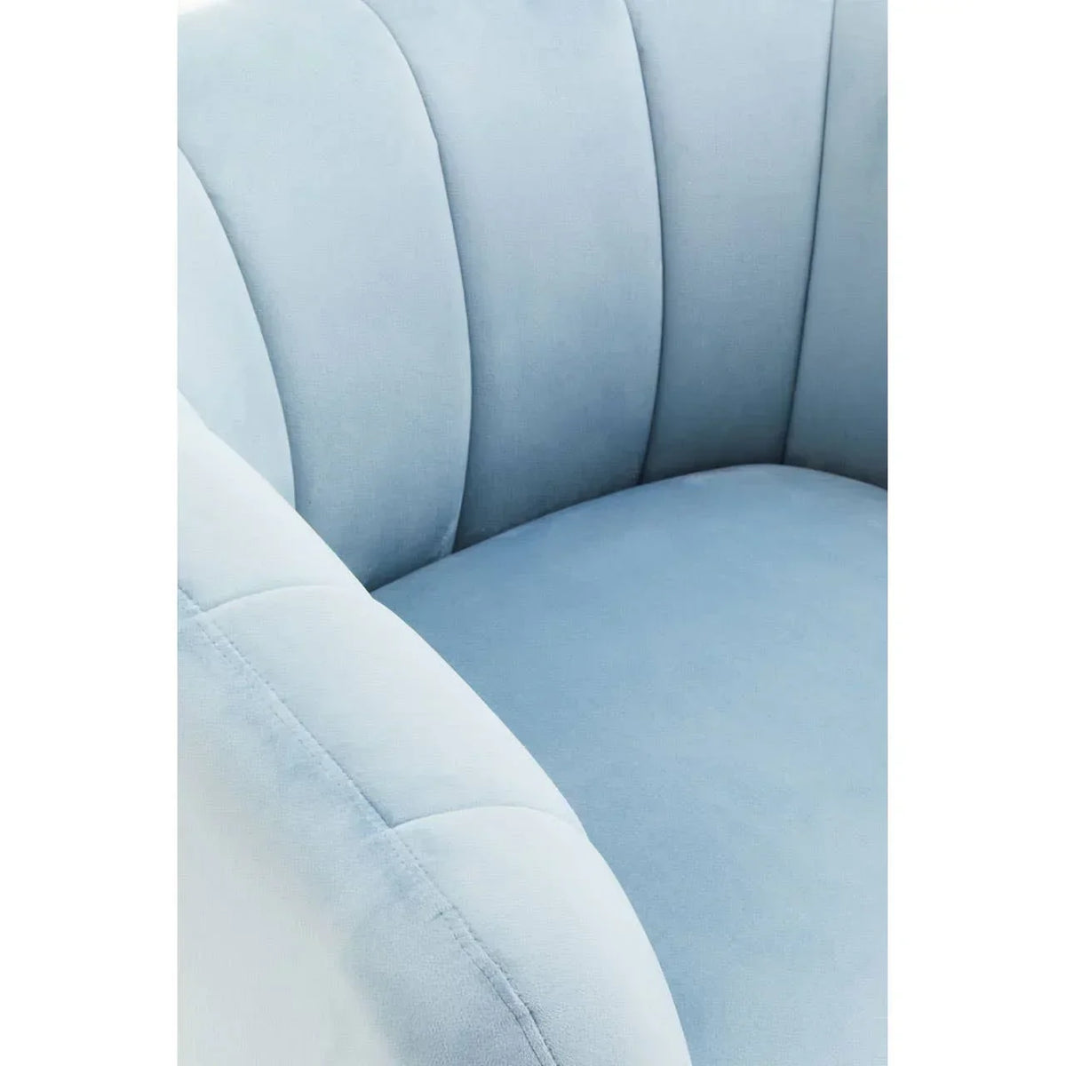 Close up of blue velvet armchair with curved backrest and stitched seam detail