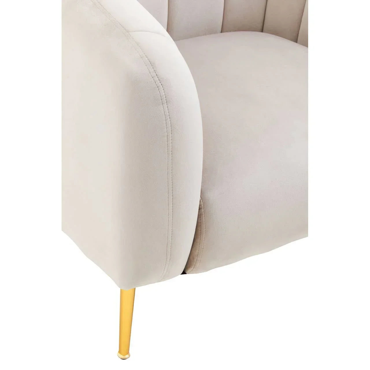 Beige velvet armchair with fluted backrest and gold metal leg, close-up view