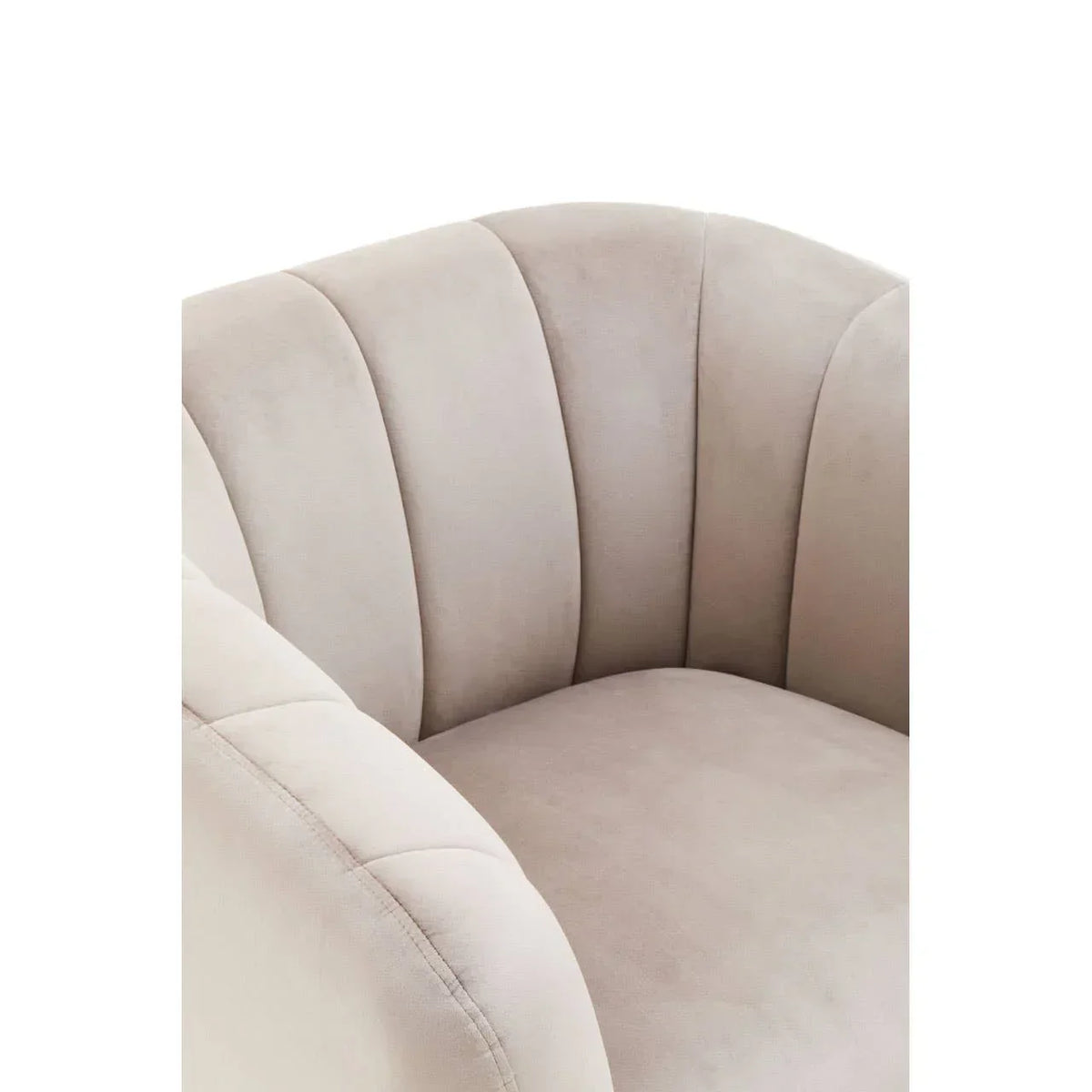 Closeup of beige velvet armchair with scalloped backrest and plush seat cushion
