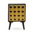 A stylish one-door cabinet featuring a mango wood body with a brass effect front, adorned with circular black knobs arranged in a grid pattern. The cabinet stands on four tapered wooden legs, showcasing a modern design suitable for home decor